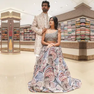 Abstract Blue Indo-Western Lehenga Set Complimented with Men's White Embroidered Sherwani